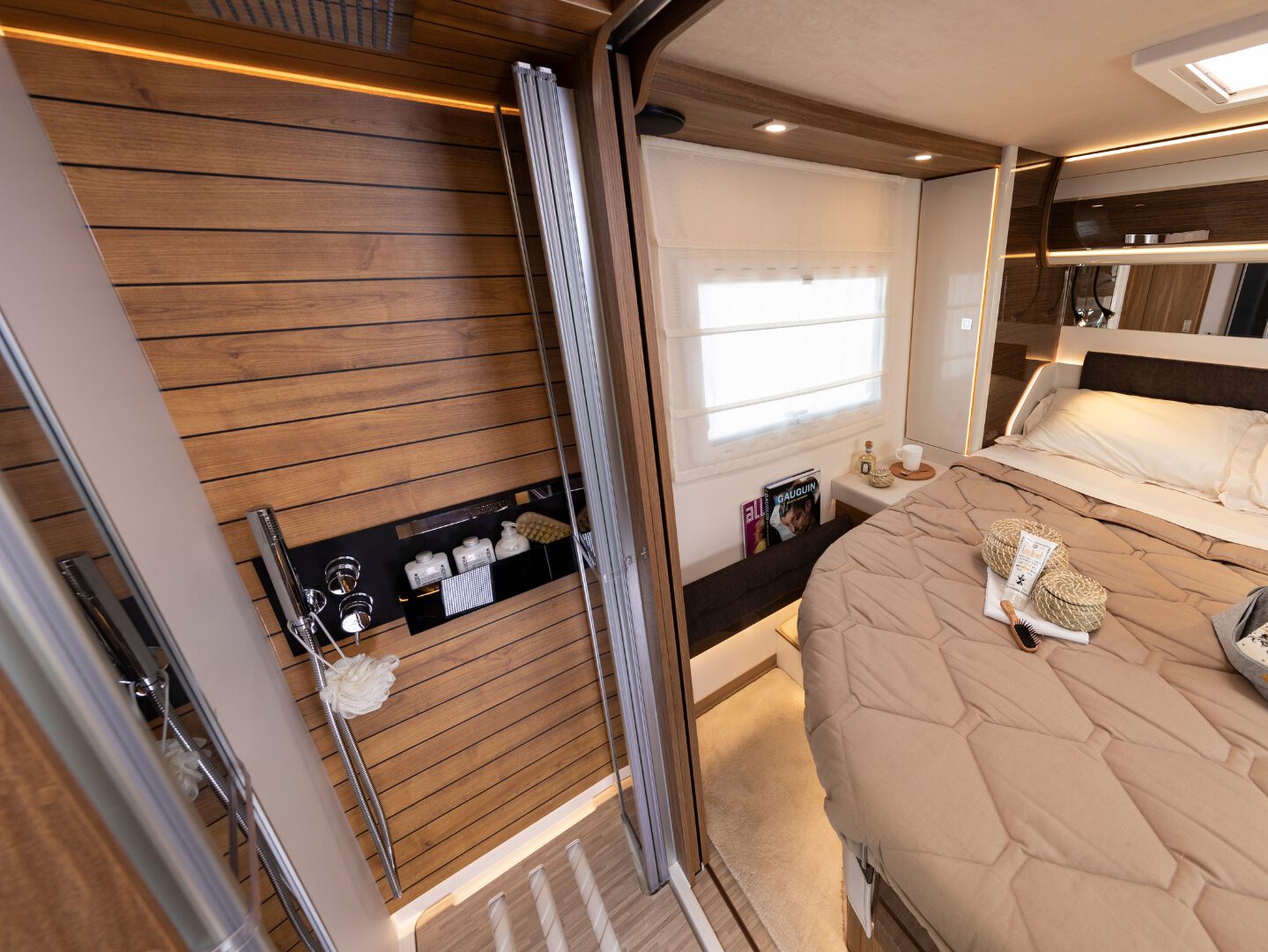 Innenansicht eines Wohnmobil-Schlafzimmers mit dunklen Holzpaneelen und modernen Möbeln, gefertigt aus Leichtbaumaterialien von Filippi 1971.